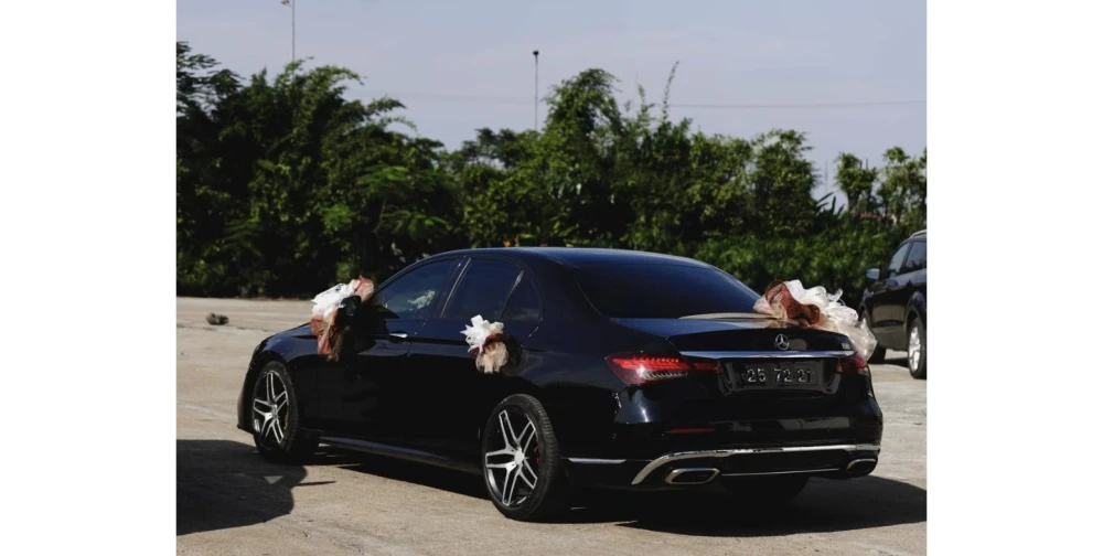 Voiture décorée pour un mariage garée devant un lieu de réception